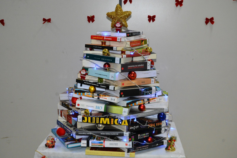 Equipe da biblioteca cria árvore natalina com livros do acervo